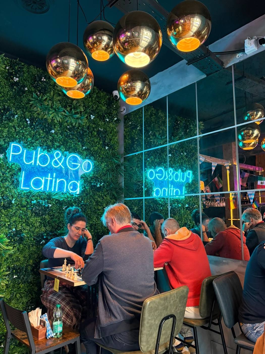 Partida bajo el neón de Pub&Go Latina